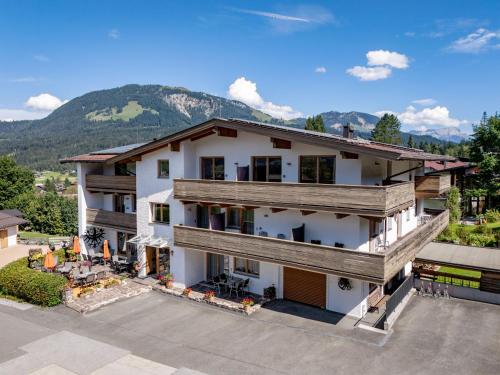 an aerial view of a house with mountains in the background at Pension Noella in Sankt Johann in Tirol
