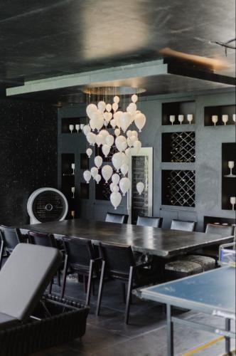 a dining room with a table and chairs and a chandelier at Palm Villa - Award Winning Modern Luxury & Exclusive Villa in Chiang Mai