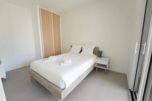 ein Schlafzimmer mit einem weißen Bett mit zwei Schüsseln darauf in der Unterkunft Joli appartement dans le centre des Herbiers in Les Herbiers
