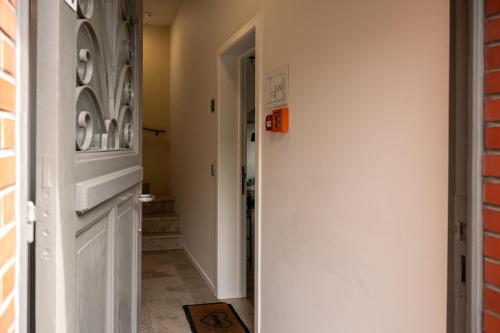 a hallway with a white door and a brick wall at Quiet and cosy apartment near the city center of Diest in Diest