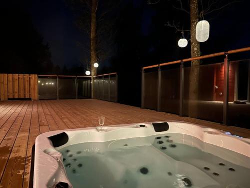 a jacuzzi tub sitting on a deck at night at Log cabin with hot tub and views in Ludvigsborg