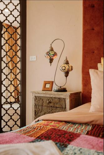 a bedroom with a bed and a lamp on a table at Palm Villa - Award Winning Modern Luxury & Exclusive Villa in Chiang Mai
