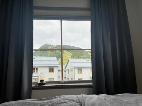 a bedroom window with a view of a house at Funäsdalshöjden Funäsdalen in Funäsdalen