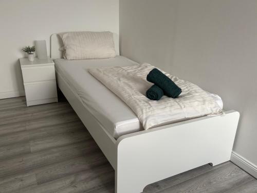 a white bed with a green pillow on it at Geräumige Ferienwohnung - ideal für Monteure in Förderstedt, Staßfurt in Staßfurt