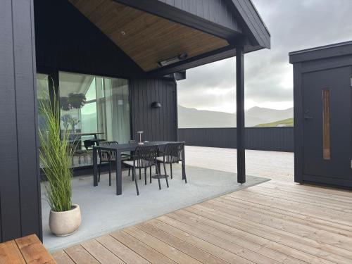 a patio with a table and chairs on a deck at Leynastova - Luxurious & Unique Villa in Leynar