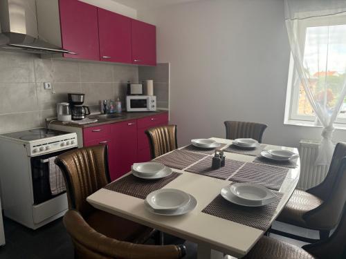a kitchen with a table with chairs and a kitchen with purple cabinets at Geräumige Ferienwohnung - ideal für Monteure in Förderstedt, Staßfurt in Staßfurt