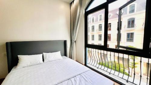 a bedroom with a bed and a large window at The Muse 3 in Ðố Sơn