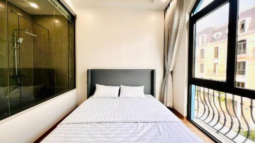 a bedroom with a bed and a large window at The Muse 3 in Ðố Sơn