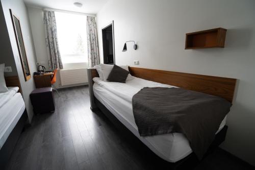 Una cama o camas en una habitación de Hótel Valaskjálf