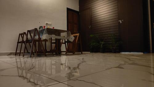 a table and chairs in a room with a reflection in the floor at Beach Stay in Kozhikode