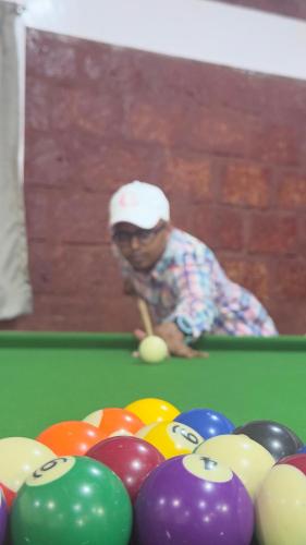 a man is playing billiard in a pool table at Magnolia Fields in Neral