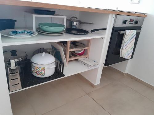 a kitchen shelf with plates and dishes on it at Sunny studio Prague in Prague