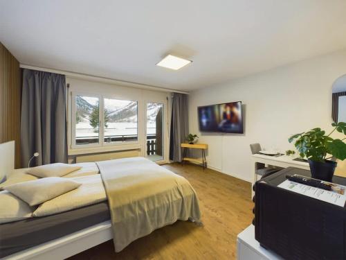 a bedroom with a large bed and a window at Panorama hideaway apartment near Zermatt with parking! in Täsch