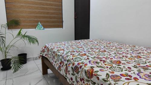 a bedroom with a bed with a flowered blanket at Beach Stay in Kozhikode