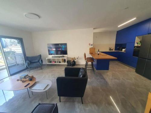 a living room with blue walls and a table and chairs at Renovated central 4 bedroom apt with great terrace and Bomb Shelter in Ramat Gan