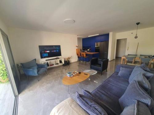 a living room with a blue couch and a table at Renovated central 4 bedroom apt with great terrace and Bomb Shelter in Ramat Gan