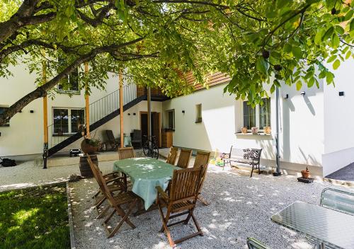 a patio with a table and chairs under a tree at Seespitz 37 - Ferienwohnungen Eisendle in Seeboden