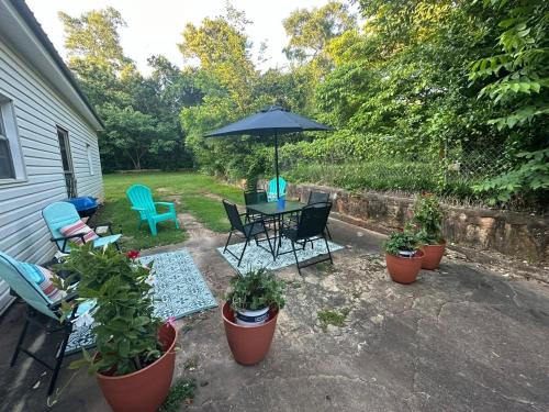 a patio with a table and chairs and an umbrella at Hannah House South Cozy country living near the city in Thomaston