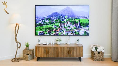 a living room with a tv hanging on a wall at Modern 3BR - Chic Coastal Escape in Abu Dhabi