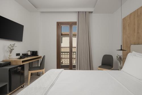 a hotel room with a bed and a desk and a window at Elysian Castle in Ioannina