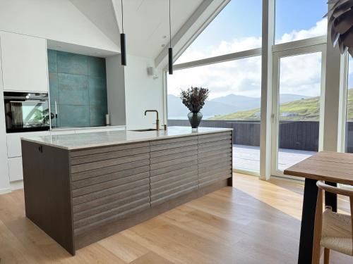 a kitchen with a sink and a large window at Leynastova - Luxurious & Unique Villa in Leynar