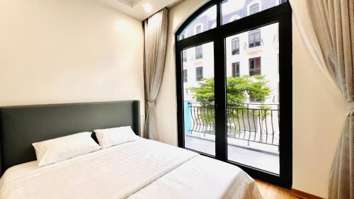 a bedroom with a bed and a large window at The Muse 3 in Ðố Sơn