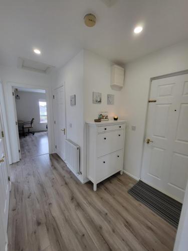 a white room with a white dresser and a door at The Happy Thoughts Place in Celbridge