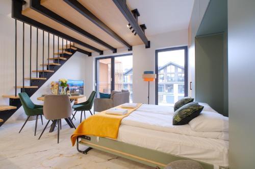 une chambre avec un lit, une table et des chaises dans l'établissement Laguna Beskidów Resort - Piwniczka Pascala, à Zarzecze