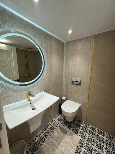 a bathroom with a sink and a toilet and a mirror at Dar Rmila à Mahdia, Borj Errass in Mahdia