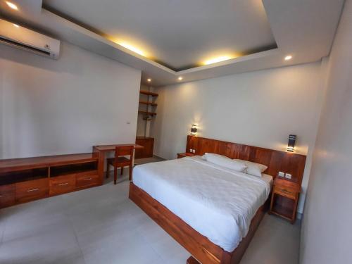 a bedroom with a large bed and a desk at San Villa Canggu - 3BR Private Pool & Fast Wifi in Dalung