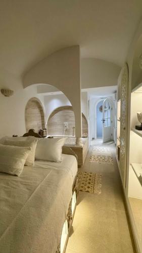 a bedroom with a large bed and an arched doorway at Dar Rmila à Mahdia, Borj Errass in Mahdia