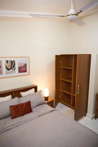 una camera da letto con un letto e un ventilatore a soffitto di DSK Residence a Accra