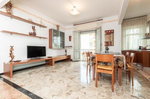 Un comedor con una mesa y un televisor. en Parcheggio Privato - 10 Min Centro Storico, en Génova