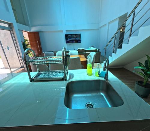 eine Küche mit Spüle und ein Wohnzimmer in der Unterkunft Casa campo las Pecanas Huaral 