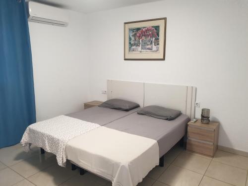 ein Schlafzimmer mit einem Bett und einem Bild an der Wand in der Unterkunft Garden City in Playa Fañabe