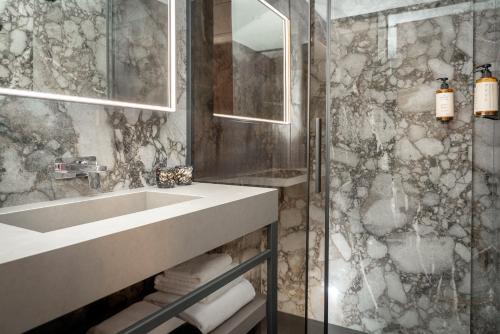 a bathroom with a sink and a glass shower at Casa Guttmann in Rome