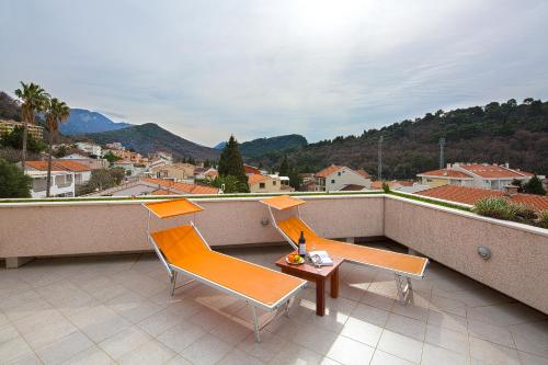 a balcony with two chairs and a table with a view at Petrovac Holiday Apartments in Petrovac na Moru