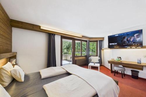 a bedroom with a large bed and a desk at Charming Little Getaway in the Heart of Saas-Fee in Saas-Fee
