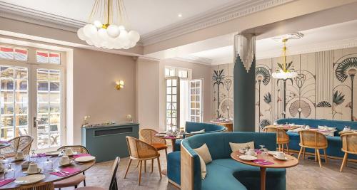 a restaurant with blue chairs and tables and windows at Best Western Poitiers Centre Le Grand Hôtel in Poitiers