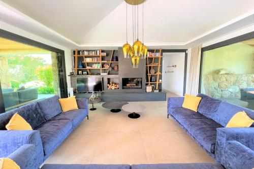 a living room with blue couches and a fireplace at Villa Pignotulli Di Cirendinu in Sainte-Lucie de Porto-Vecchio