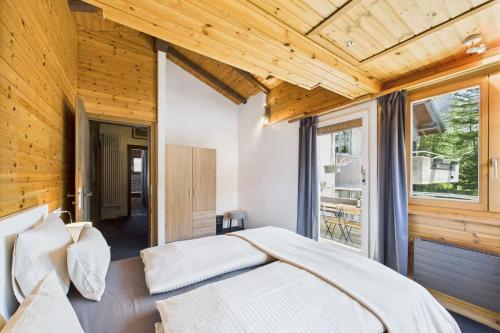 a bedroom with a large bed and a large window at Family & friends cabin in Saas-Fee in Saas-Fee