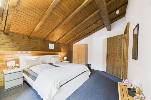 a bedroom with a large white bed and wooden ceilings at Family & friends cabin in Saas-Fee in Saas-Fee