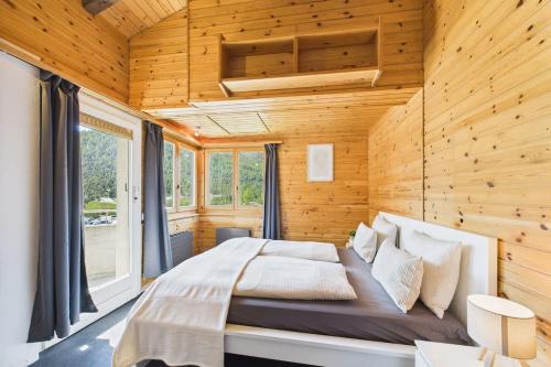 a bedroom with a large bed in a wooden wall at Family & friends cabin in Saas-Fee in Saas-Fee