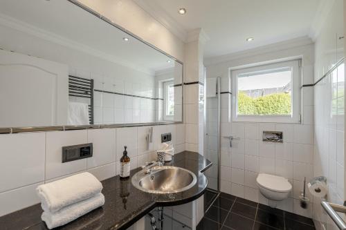 a bathroom with a sink and a toilet at Meer in Süderende