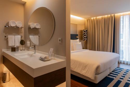 a hotel room with a bed and a mirror at Palácio do Governador - Lisbon Hotel & Spa in Lisbon