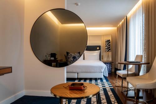 a hotel room with a bed and a large mirror at Palácio do Governador - Lisbon Hotel & Spa in Lisbon
