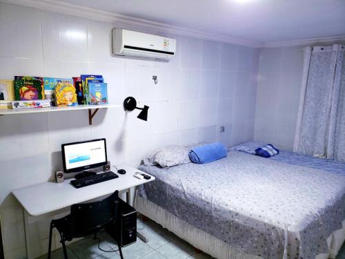 sypialnia z łóżkiem i biurkiem z komputerem w obiekcie Casa Campina Grande-PB, Piscina, Wifi, Ar. w mieście Campina Grande