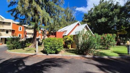 a house on a street with trees and bushes at Penthouse de 2 chambres, accès directe à la plage, Bain Boeuf in Bain Boeuf