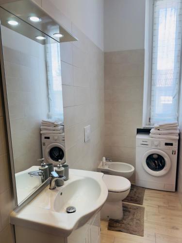 a bathroom with a sink and a toilet and a mirror at Era apartments 2 in Caponago