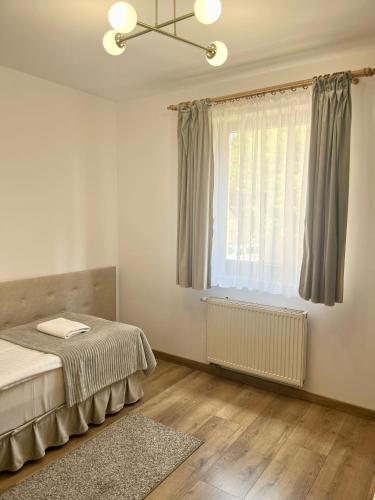 a bedroom with a bed and a window and a rug at Hotel i Restauracja Borowianka in Ostrów Wielkopolski